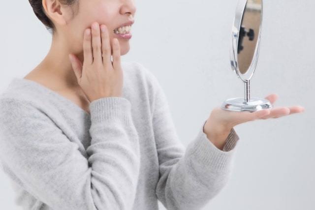 虫歯の状態を鏡で確認する女性
